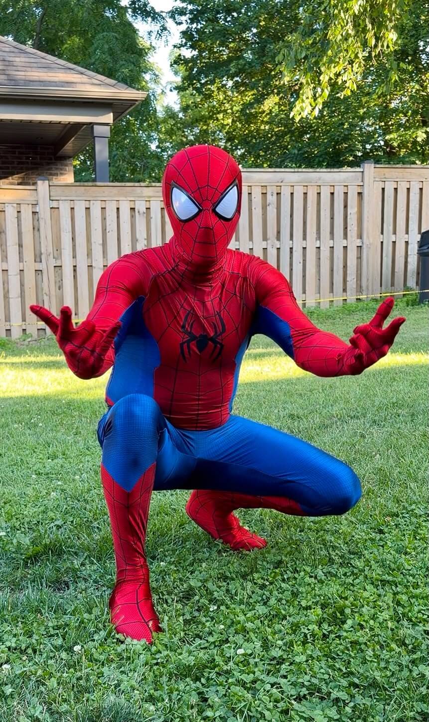 Web-slinging superhero entertainer posing outdoors