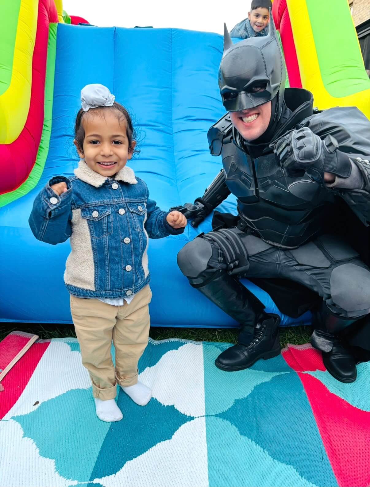 Young child posing with a superhero entertainer